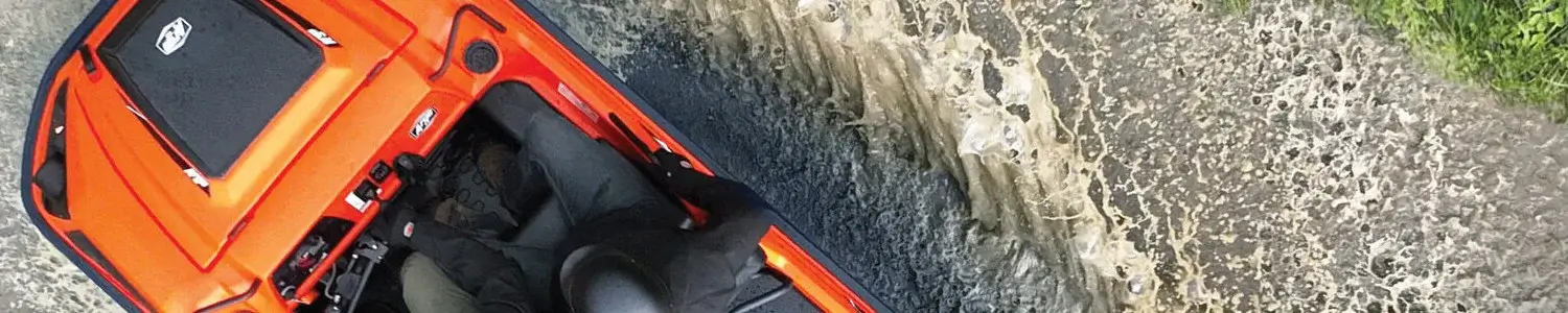 Orange ATV riding through mud
